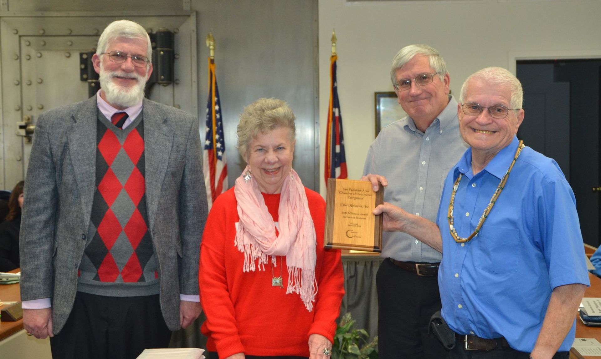 A group of people standing next to each other holding a plaque