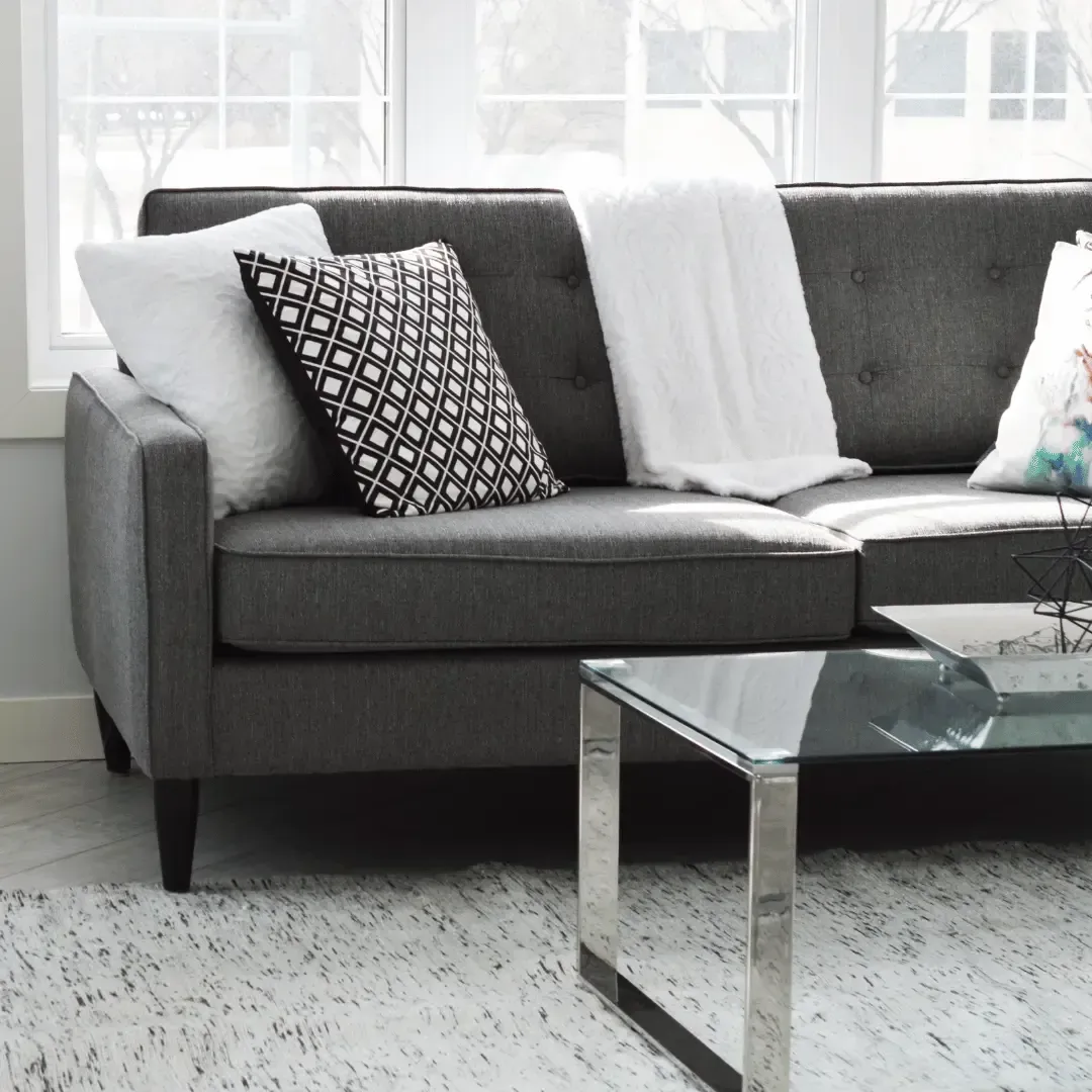 Advanced Carpet Cleaning technician utilising a professional low-moisture thermal extraction tool to remove deep-seated body oils from a fabric lounge suite couch.
