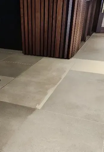 Beige tile floor with a dark wood panel wall.