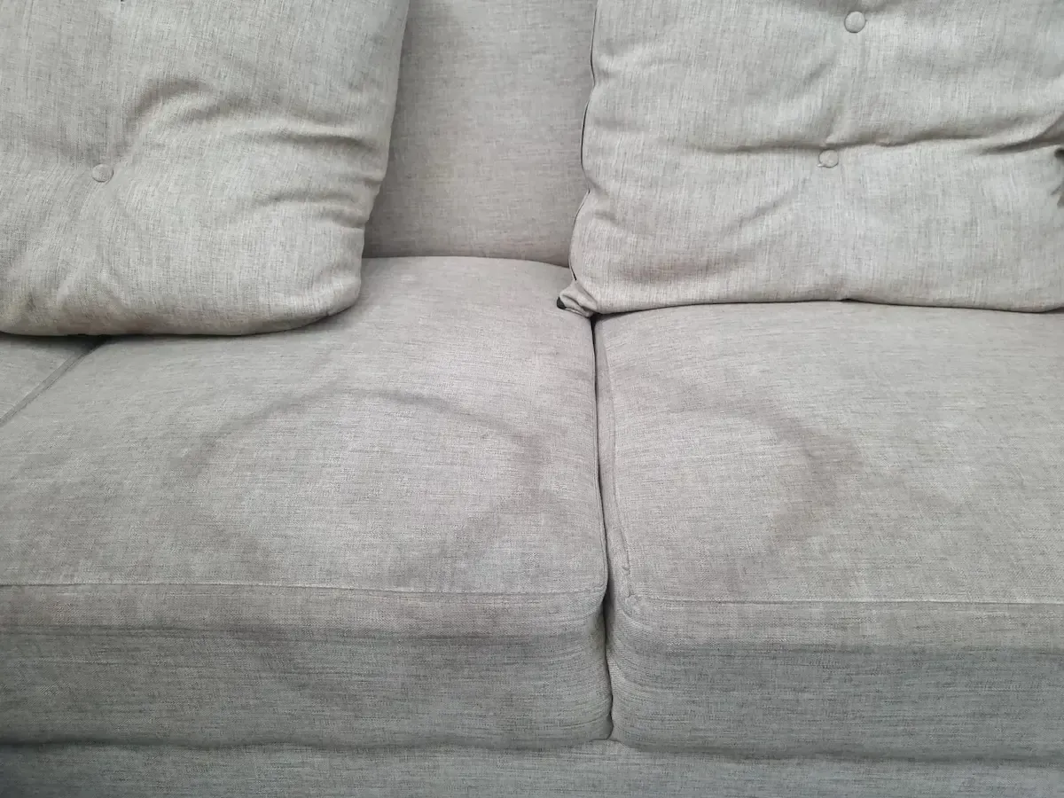 Beige sofa cushions with circular imprints.