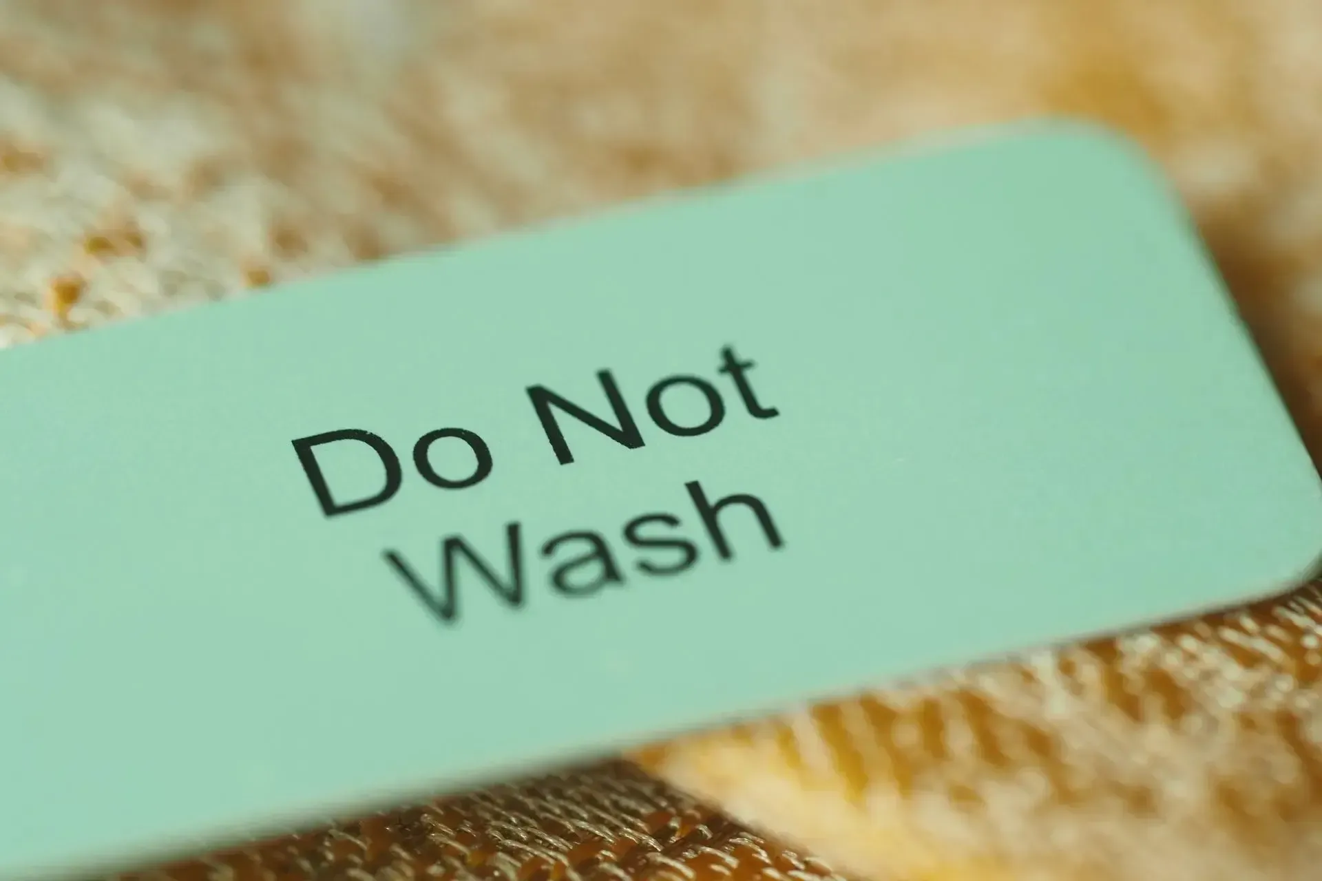 Mint-green “Do Not Wash” label on fabric
