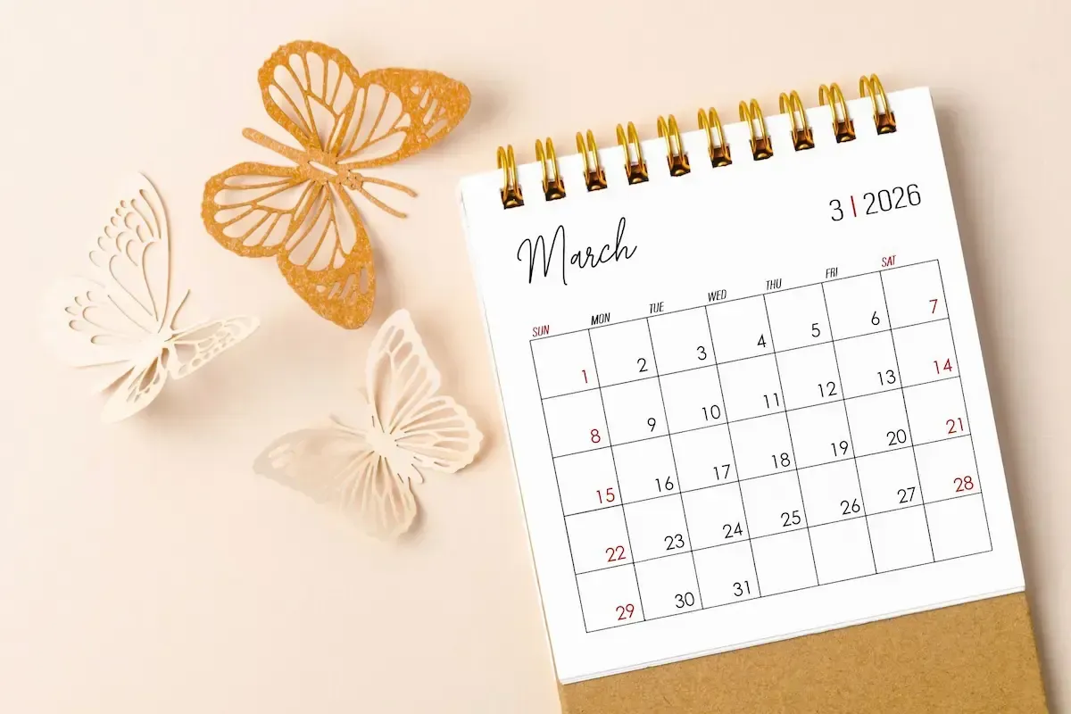 March 2026 calendar with gold spiral binding, butterflies. Neutral background, soft colors.