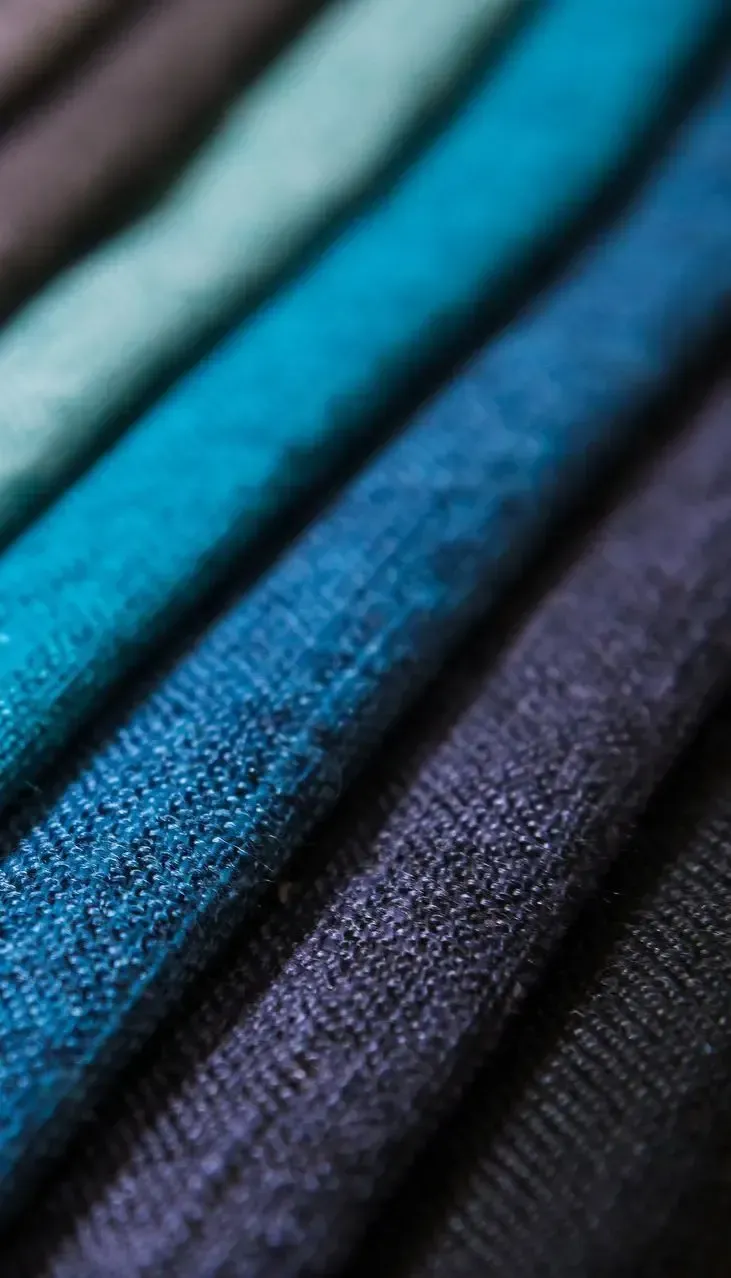 A close up of a stack of different colored fabrics.