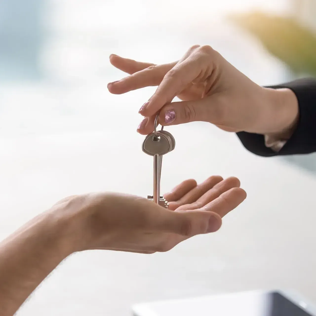 A woman in a suit is smiling and holding a clipboard