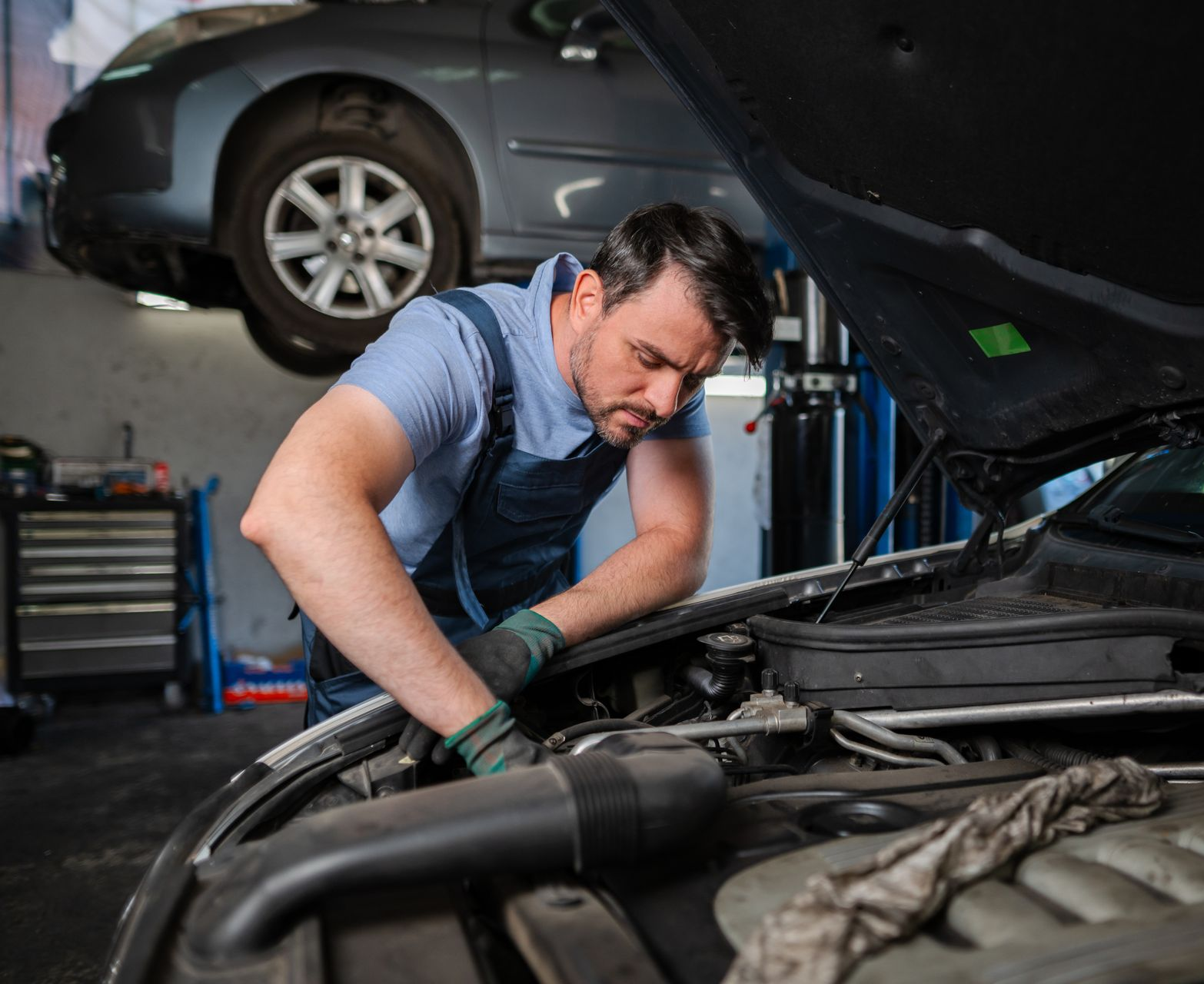 Technician performing engine repair on a vehicle