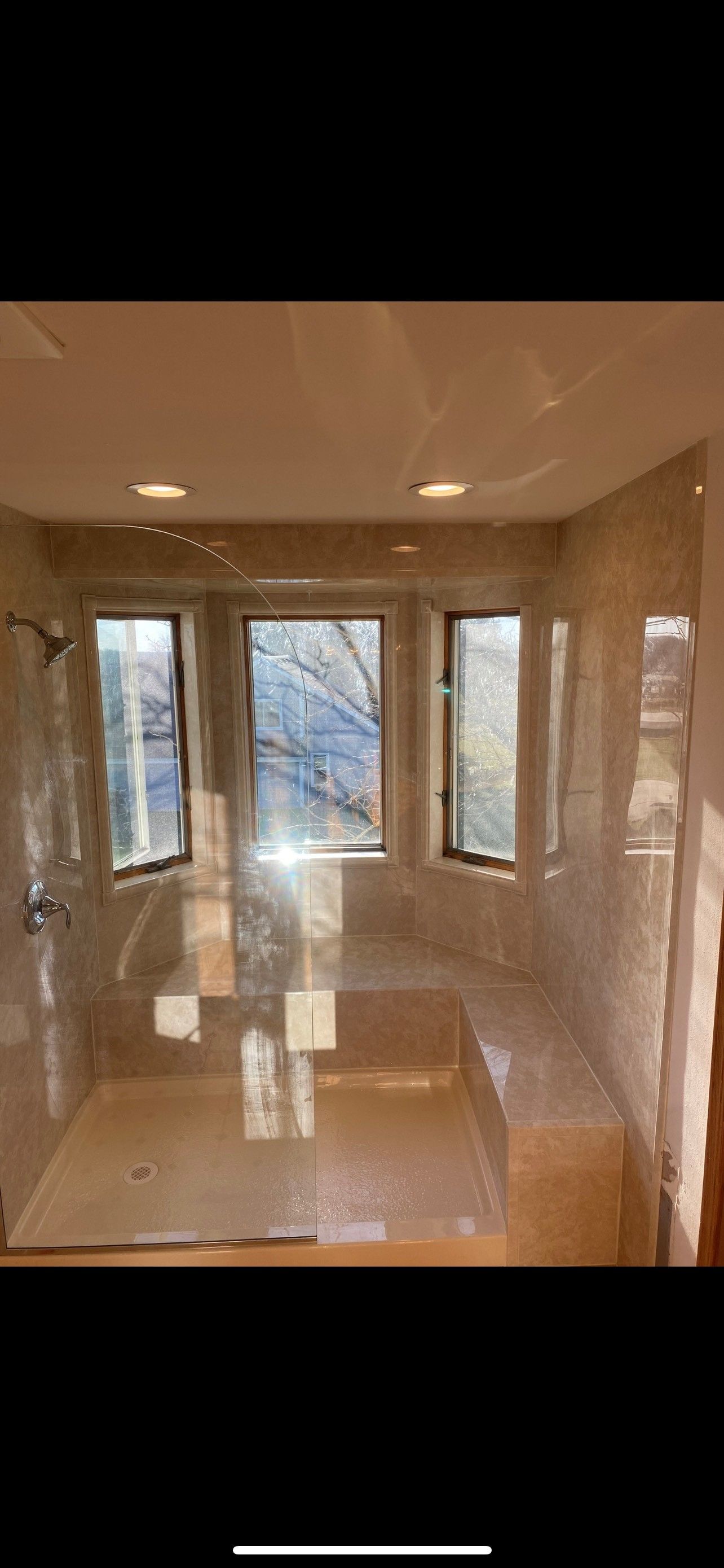 Bathroom with three windows, a built-in bench, and tiled walls and floors.
