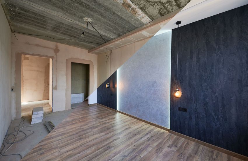 Una stanza vuota con pavimenti in legno e un soffitto in fase di ristrutturazione.