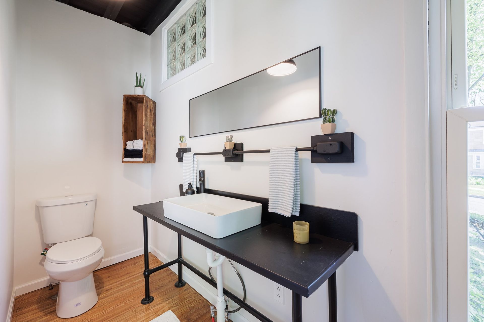 A bathroom with a toilet , sink and mirror.