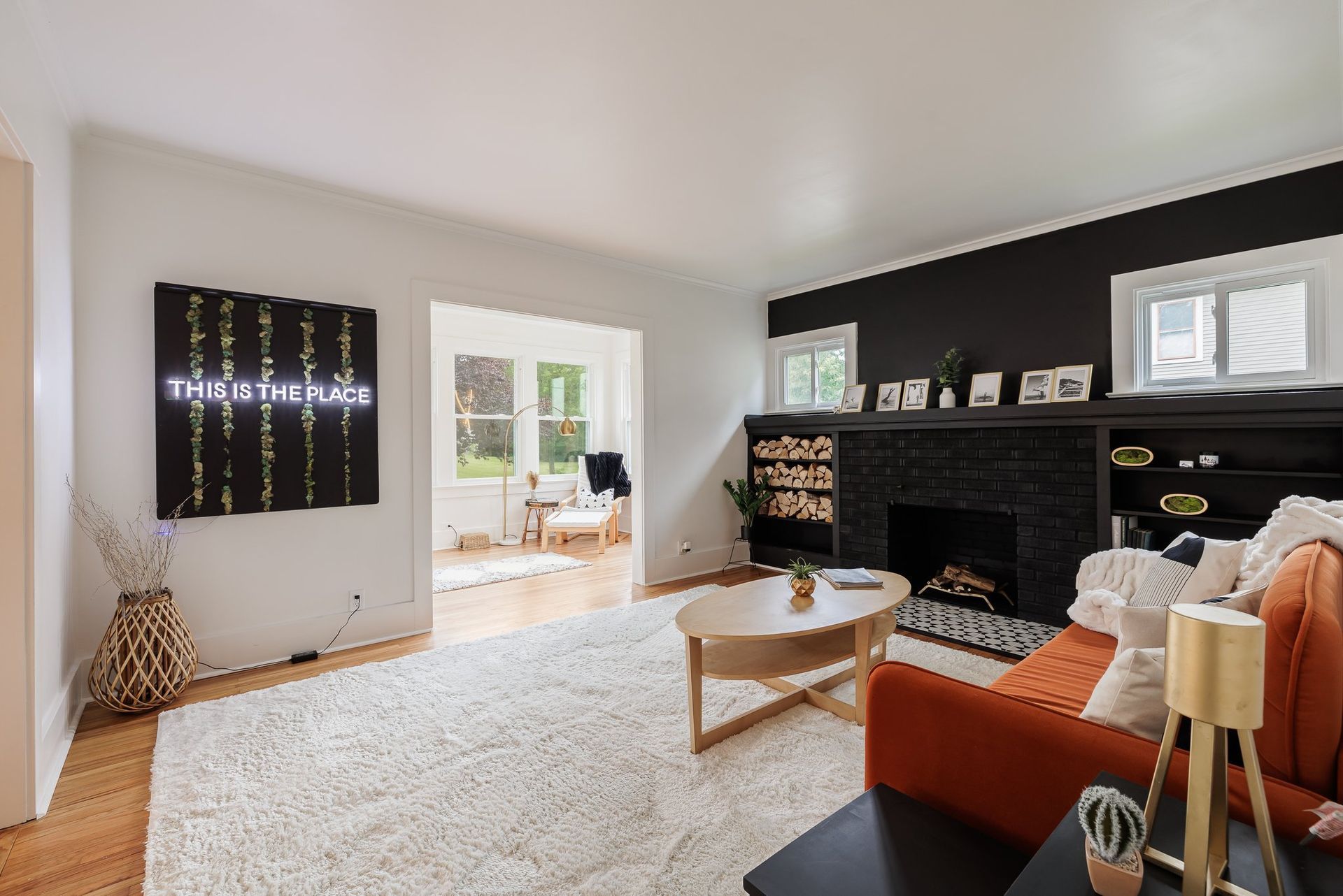 A living room with a couch , coffee table , fireplace and a painting on the wall.