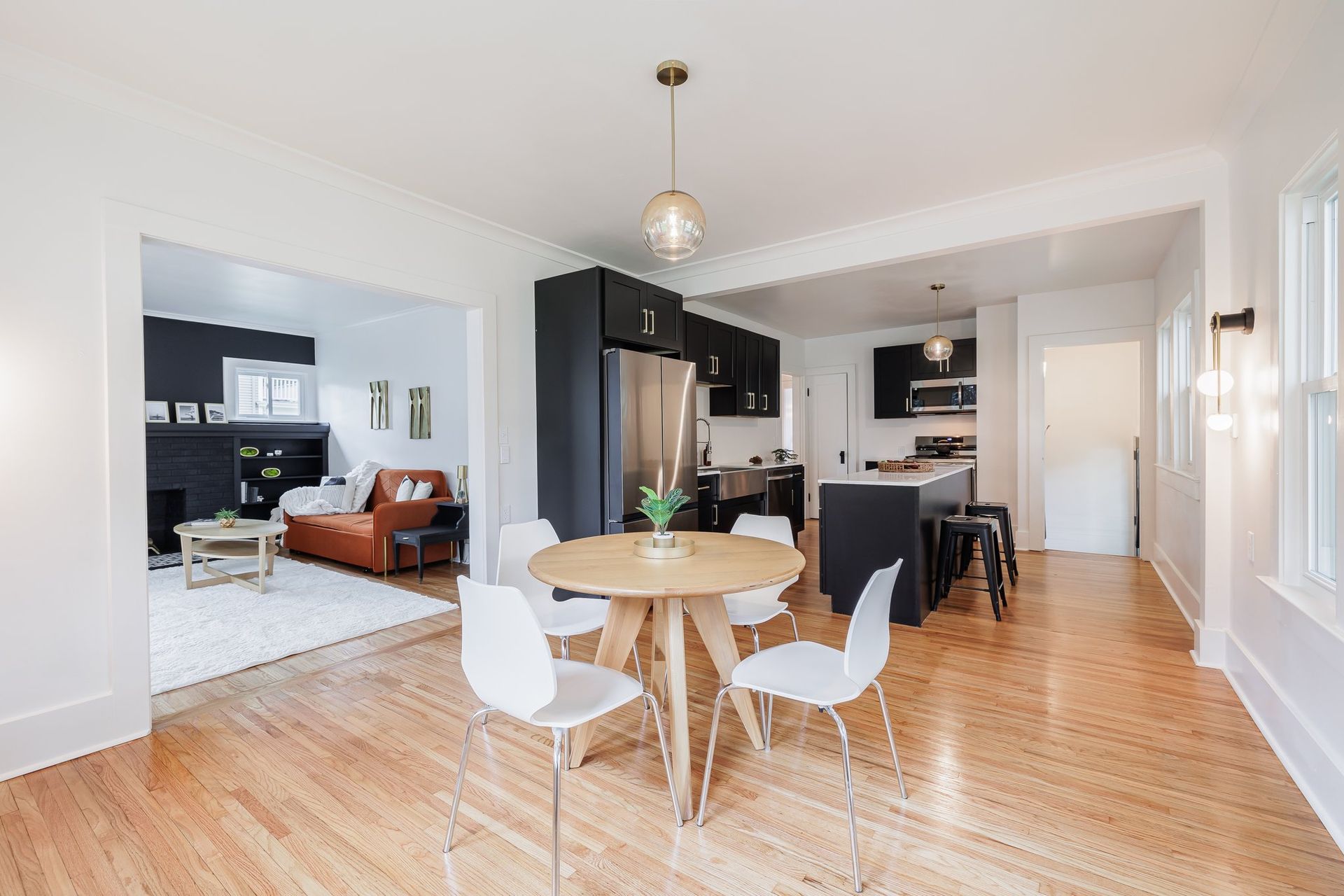 A living room with a dining table and chairs and a kitchen.