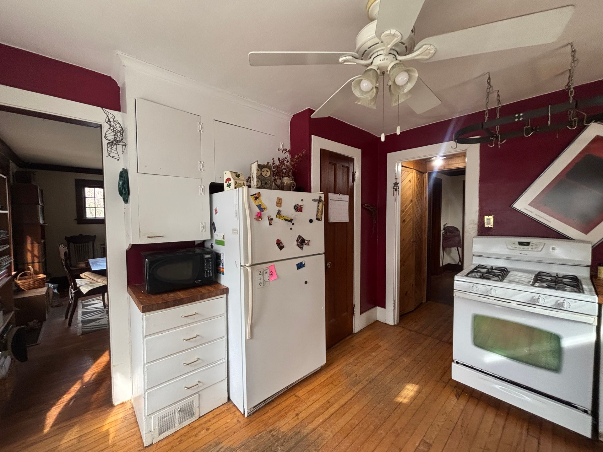 An empty living room with hardwood floors and a fireplace.
