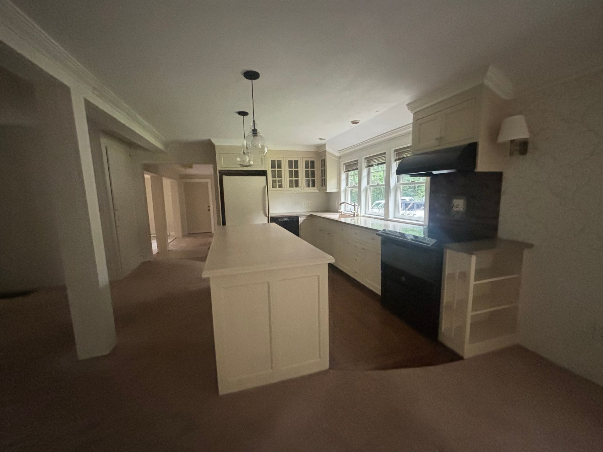 An empty kitchen with a large island in the middle