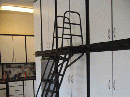 A kitchen with a ladder leading up to a loft