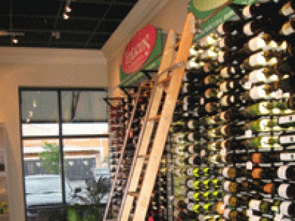 A wall filled with lots of wine bottles and a ladder
