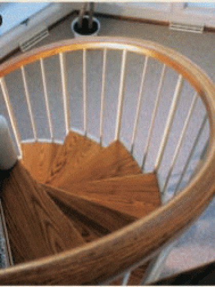 A wooden spiral staircase with a white railing