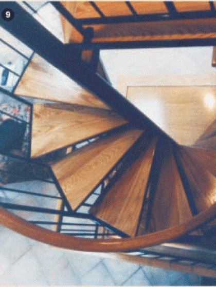 A wooden spiral staircase with a metal railing