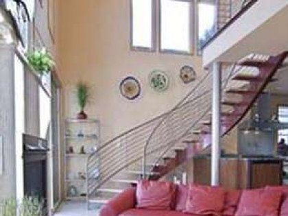 A living room with a red couch and stairs leading to the second floor.