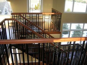 A staircase with a wooden railing and a metal railing