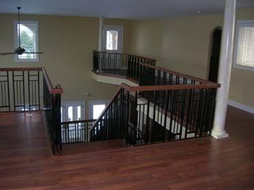 An empty room with a staircase and a ceiling fan