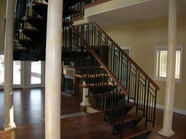 An empty room with a spiral staircase and columns