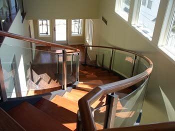 A curved staircase with a glass railing in a house