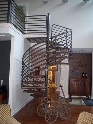 A spiral staircase is in the middle of a living room.