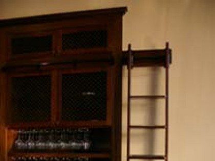 A wooden cabinet with a ladder attached to it.