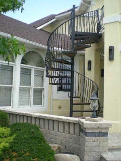 A spiral staircase on the side of a house