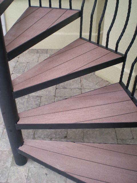 A spiral staircase with wooden steps and black railing