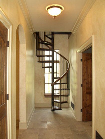 A hallway with a spiral staircase in the middle