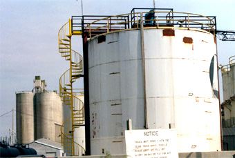 A large white tank with a spiral staircase and a sign that says notice