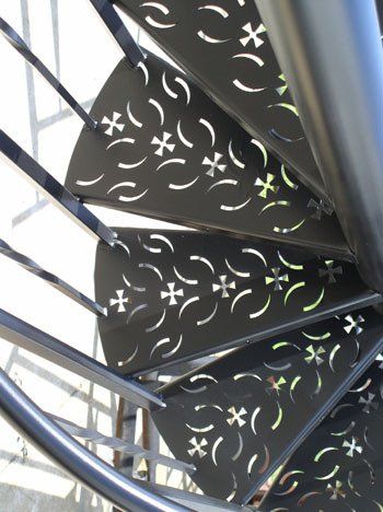 A close up of a spiral staircase with a pattern on the steps