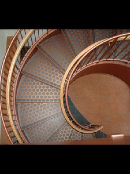 A close up of a spiral staircase with a wooden railing