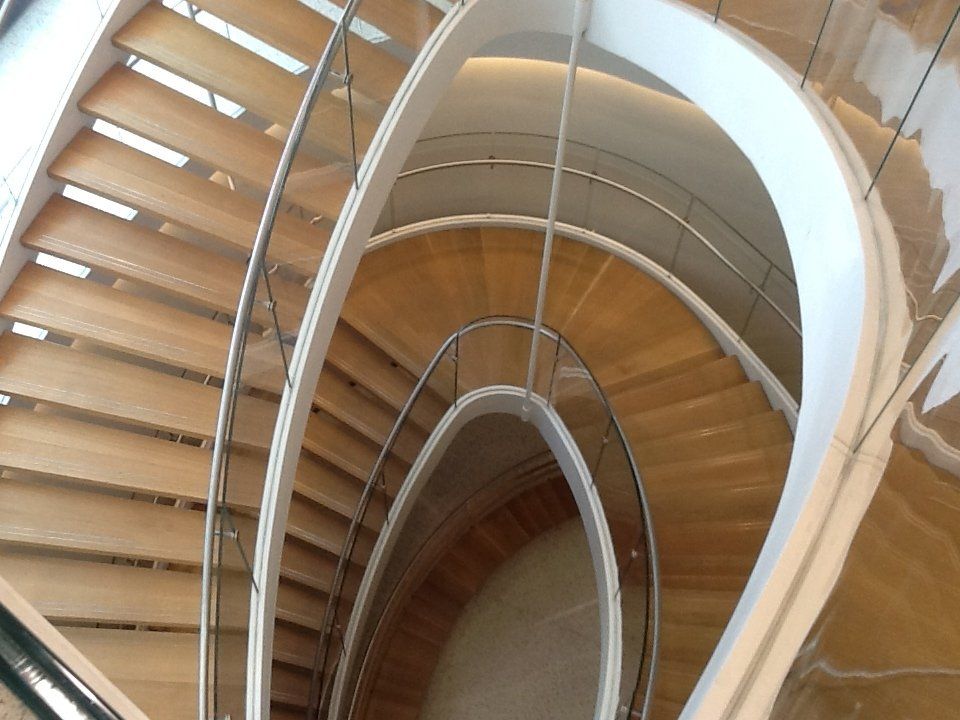 wooden spiral stair with metal and glass railings