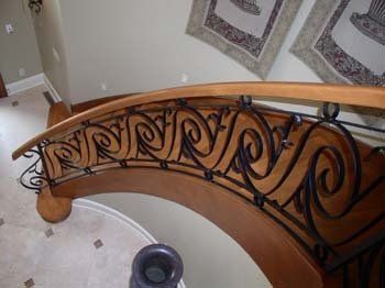 A wooden staircase with a wrought iron railing in a house.