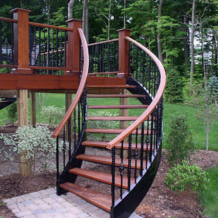 A wooden spiral staircase with a black railing