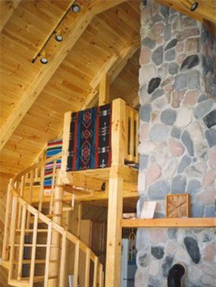 A wooden staircase leading up to a stone fireplace