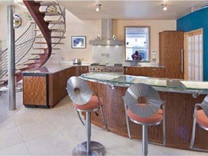 A kitchen with a staircase leading up to the second floor