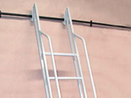A white metal ladder is attached to a pink wall.