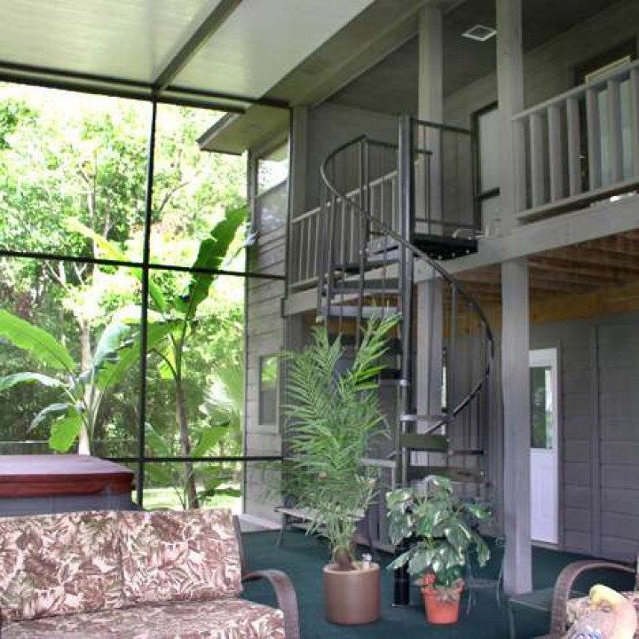 A living room with a couch and chairs and a spiral staircase