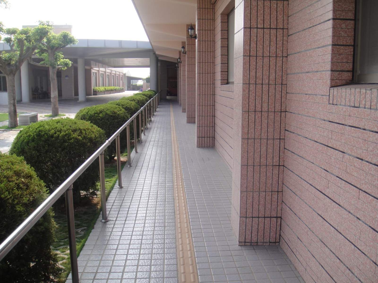 東明護理之家二林院區戶外無障礙廊道,設不鏽鋼扶手與導盲磚引導