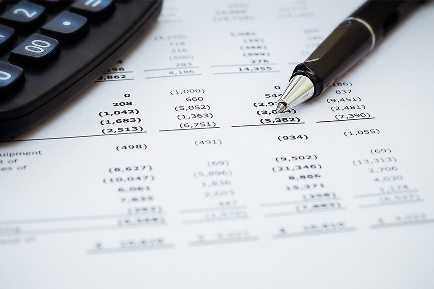pen and calculator on accounting report