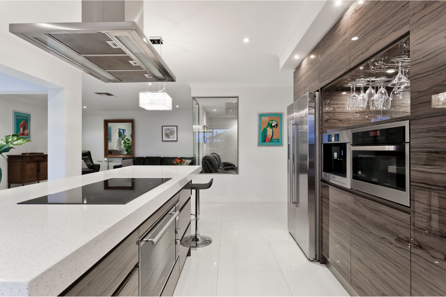 Modern kitchen with white countertops, stainless steel appliances, and wood cabinets.
