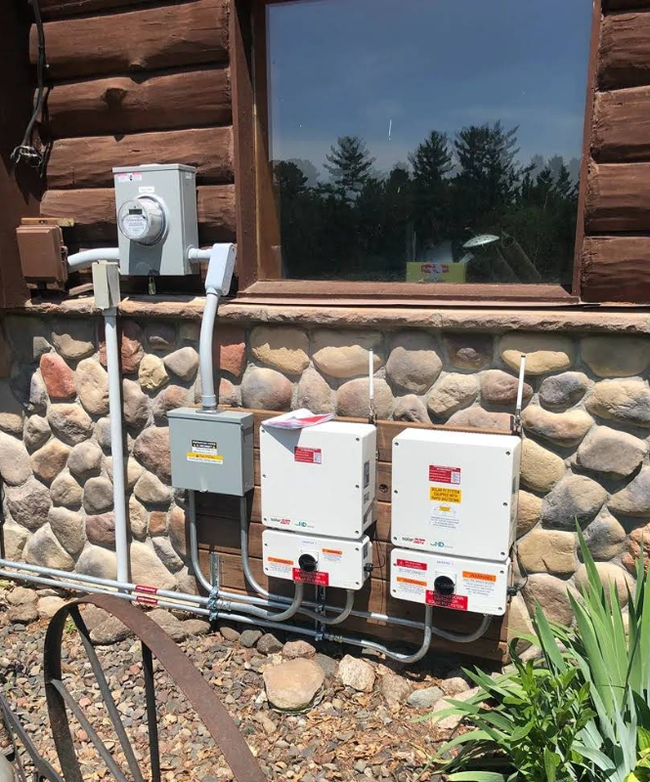 Three utility boxes and meter mounted on a stone wall beneath a window