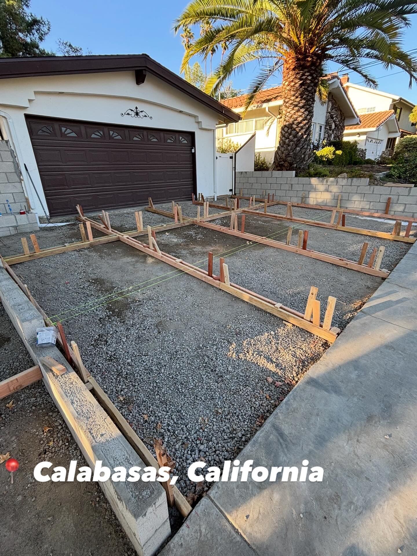 Concrete foundation forms in a driveway beside a garage, labeled Calabasas, California.