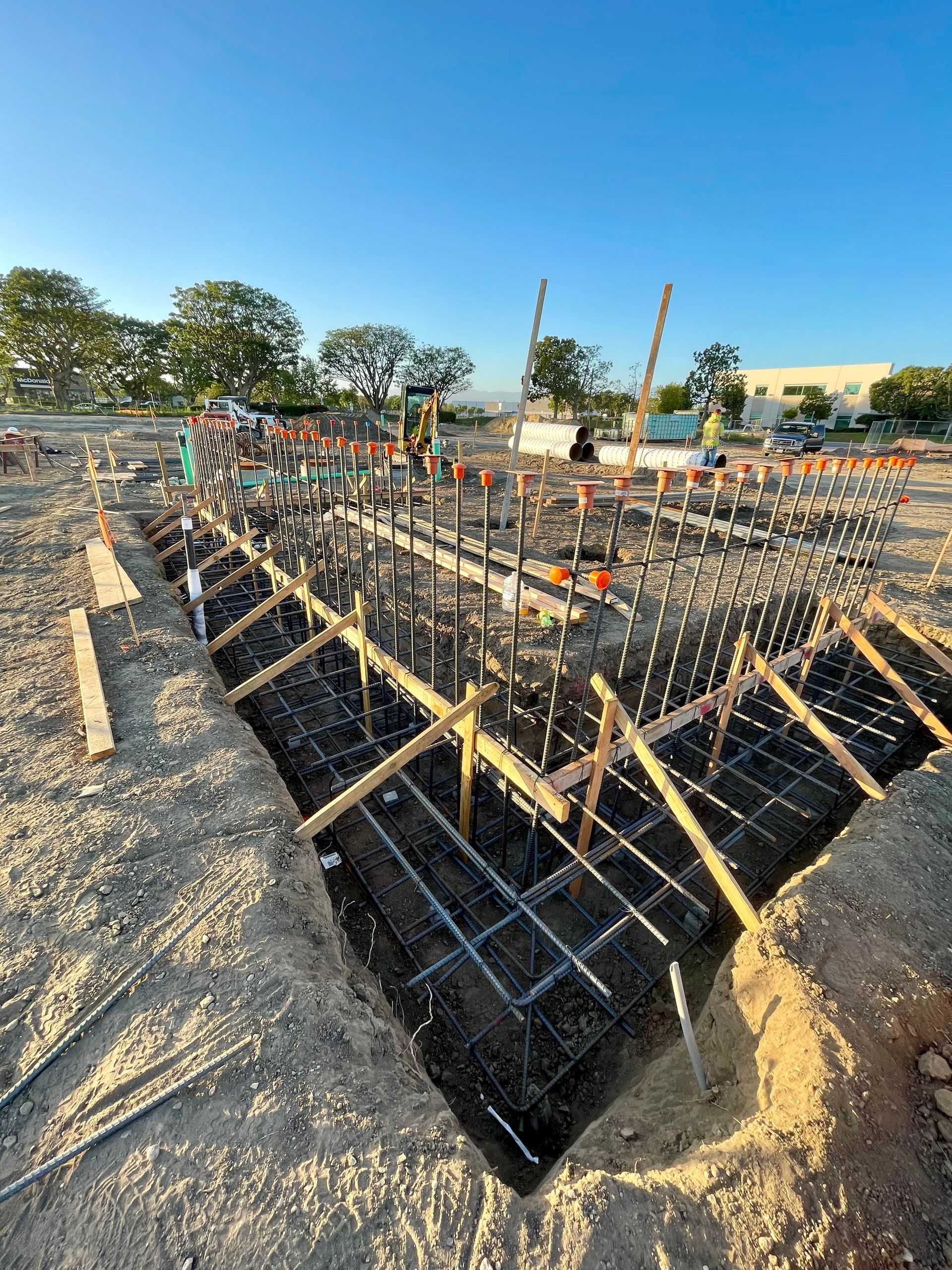 Construction site with rebar grid and wooden forms for a concrete foundation pit