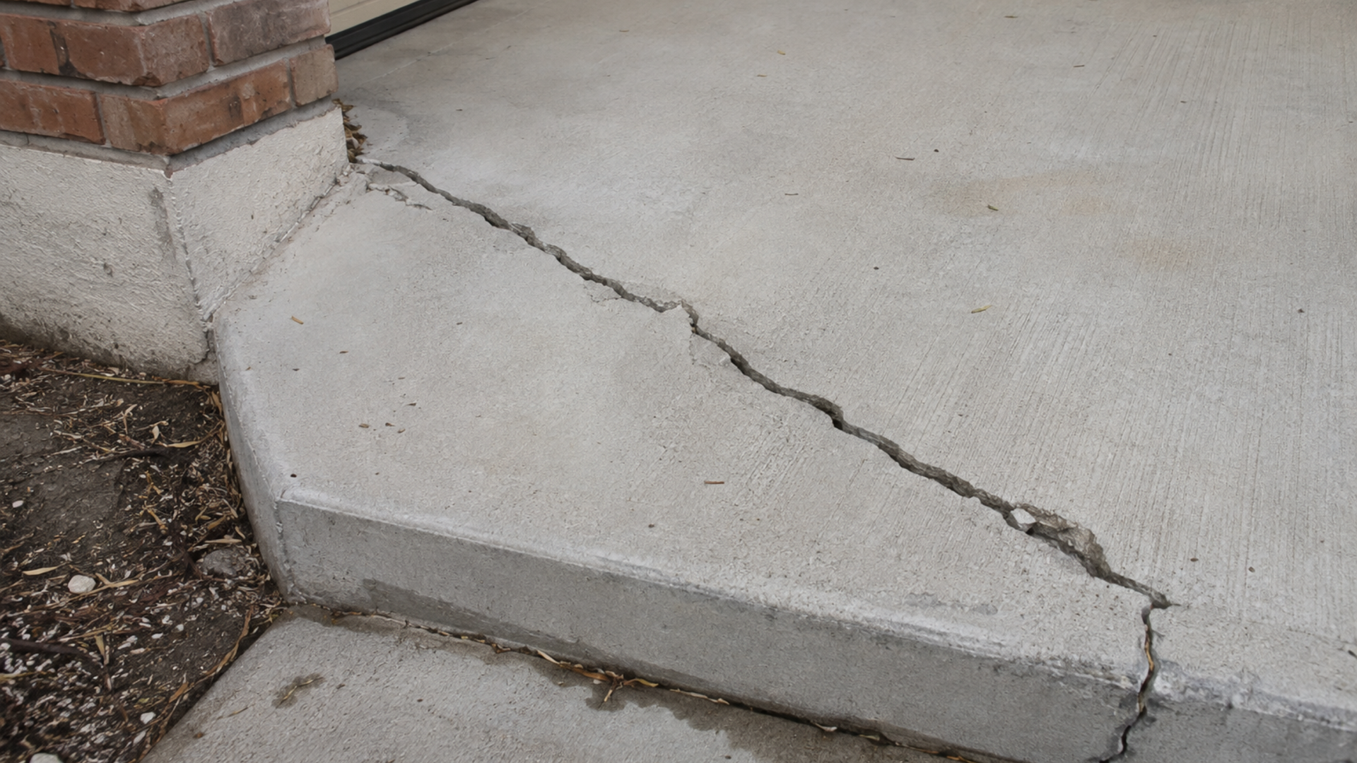 Wide diagonal structural crack running from the corner of a concrete slab
