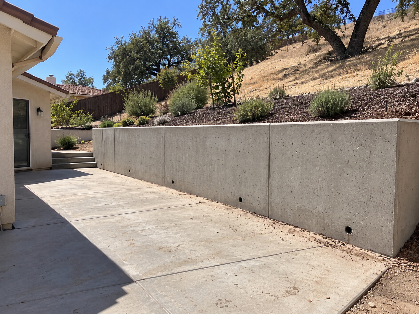 Engineered hillside retaining wall holding back a sloped yard in Thousand Oaks