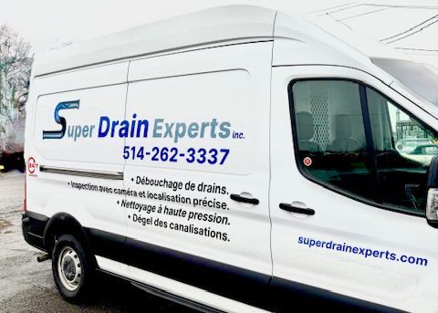 White Super Drain Experts service van with company logo, phone number, and website on the side.