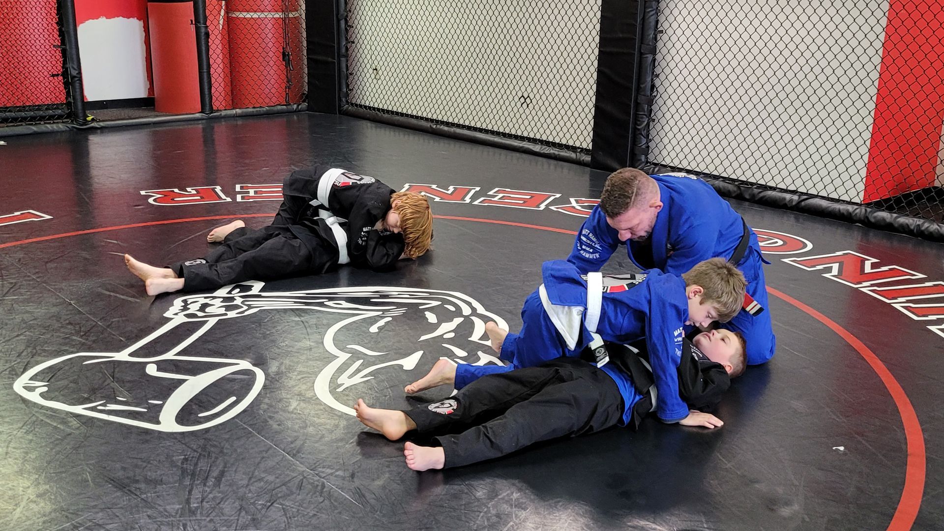 A group of people are laying on the floor in a boxing ring.